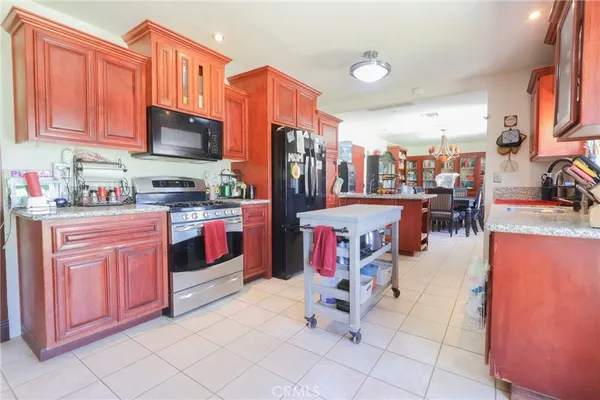 a kitchen with stainless steel appliances granite countertop a stove top oven a sink dishwasher and cabinets with flat screen tv