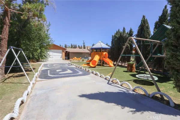 a view of a backyard with a slide and a wooden floor