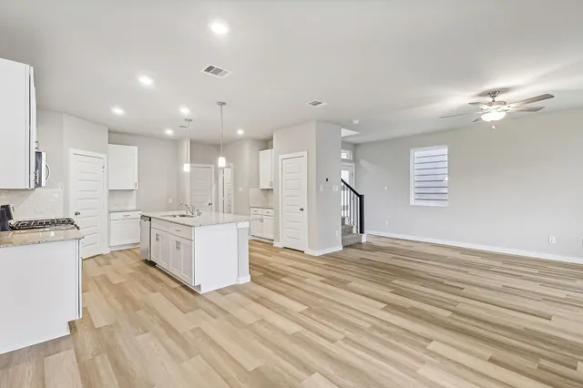 a view of a kitchen with kitchen island and stainless steel appliances