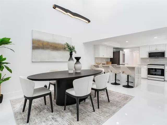 a kitchen with white cabinets appliances a sink and a window