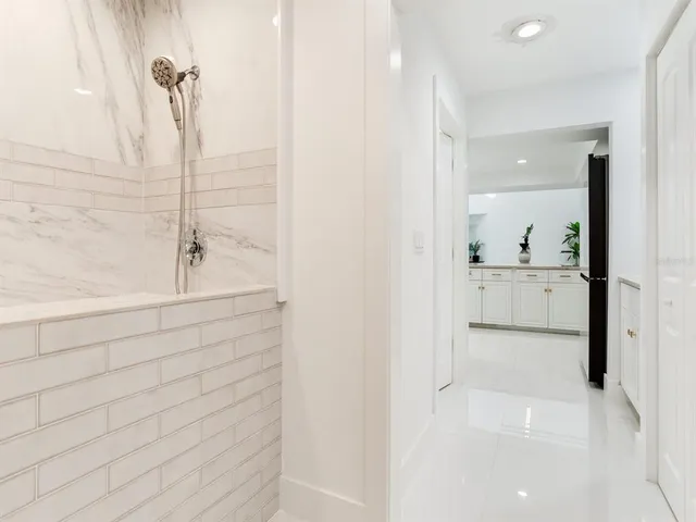 a bathroom with a sink a mirror a bathtub and shower