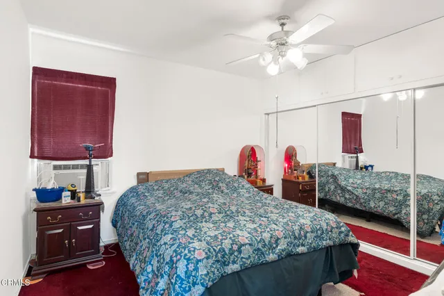 a bedroom with bed and a flat tv screen