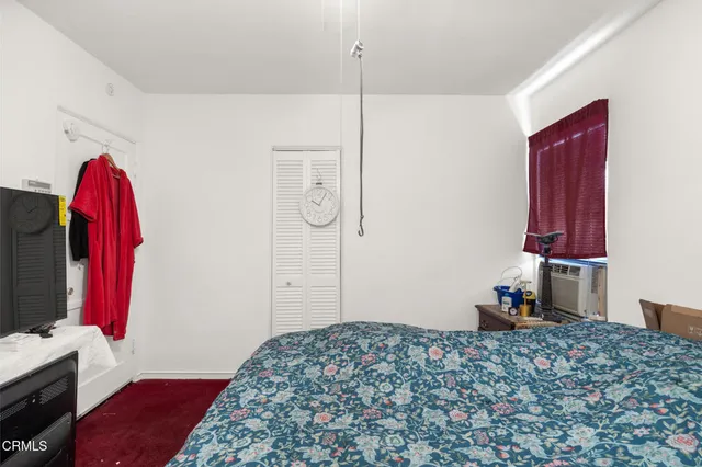 a bedroom with a bed and a flat tv screen