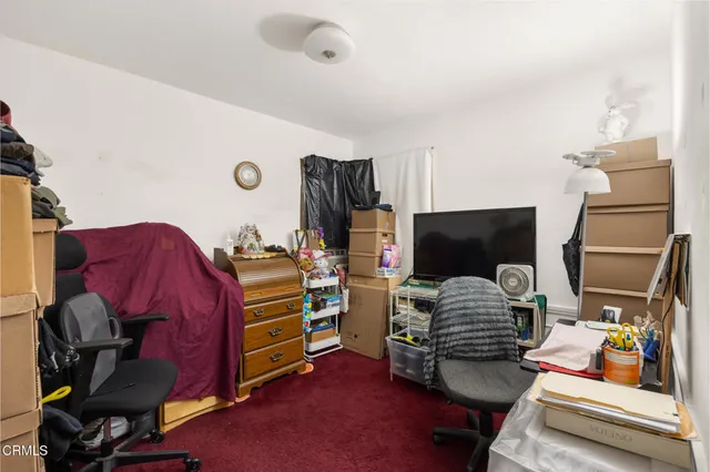 a view of a livingroom with furniture and clothes
