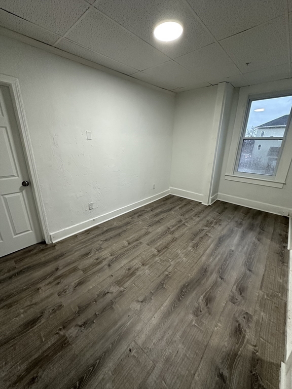 126 Lincoln Street, Unit 1L Worcester, MA 01605 - Photo 2 of 10 an empty room with wooden floor and window