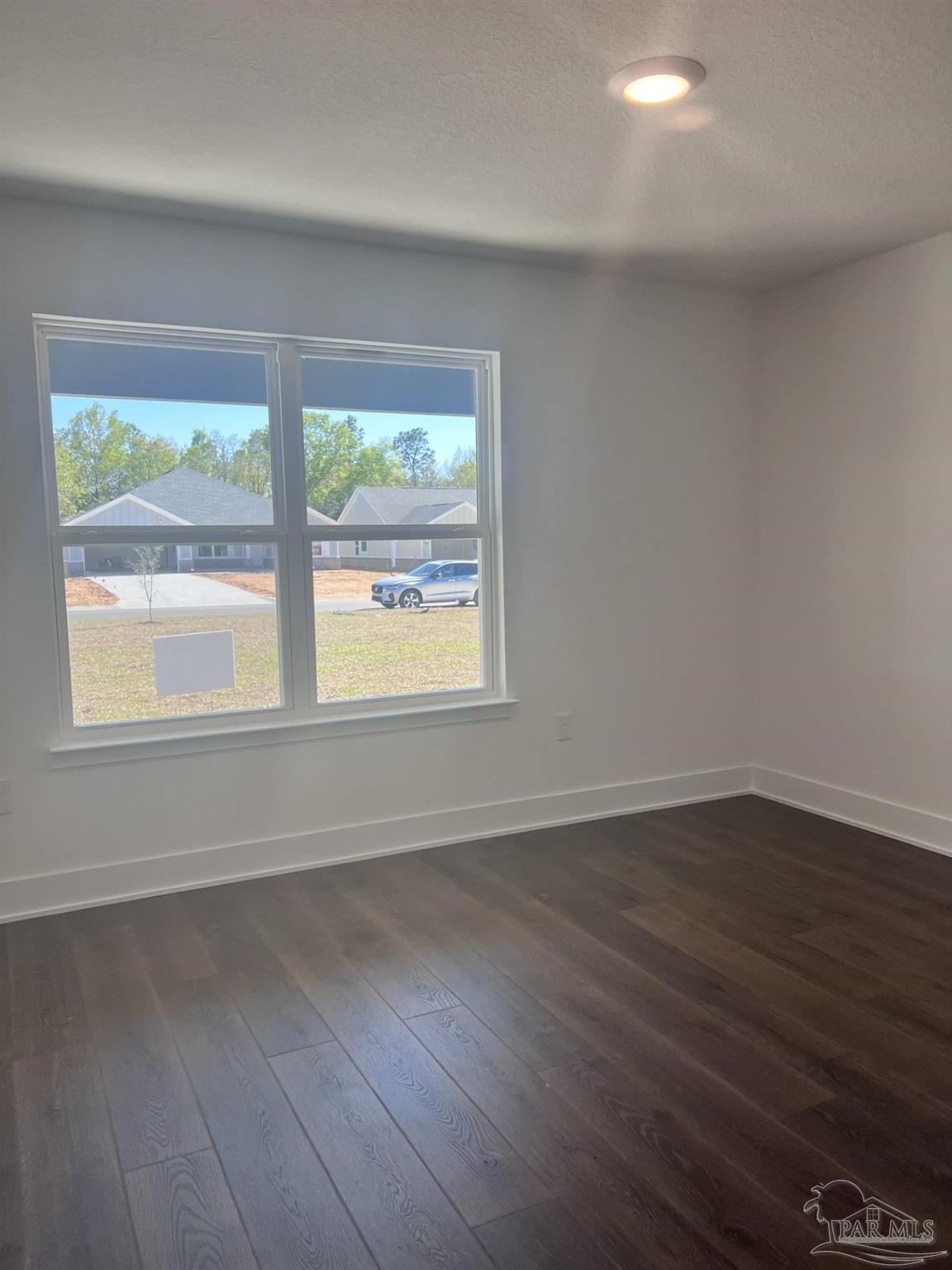 5232 Muscadine Way Milton, FL 32570 - Photo 17 of 23 a view of an empty room with wooden floor and a window