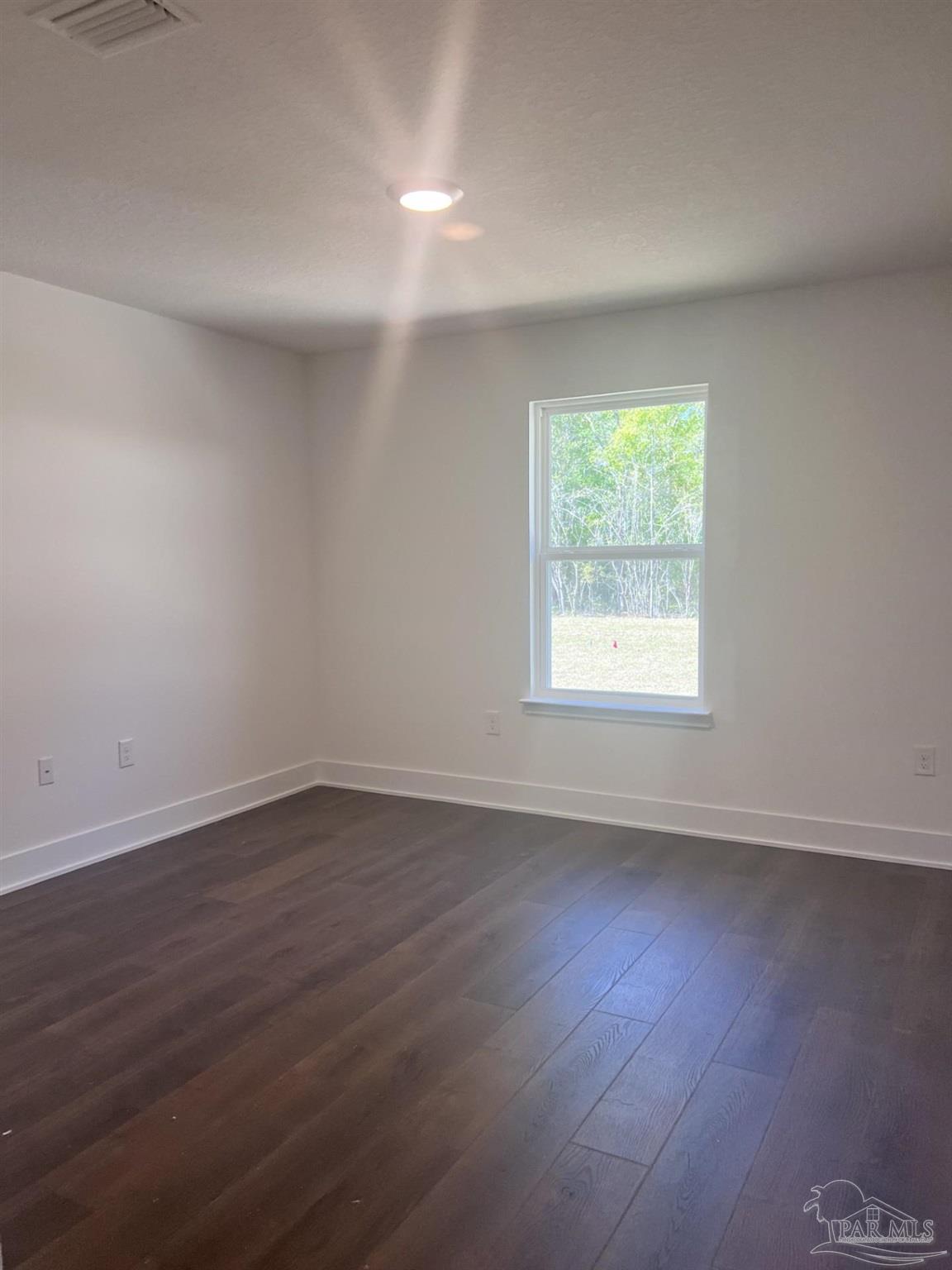 5232 Muscadine Way Milton, FL 32570 - Photo 19 of 23 an empty room with wooden floor and windows