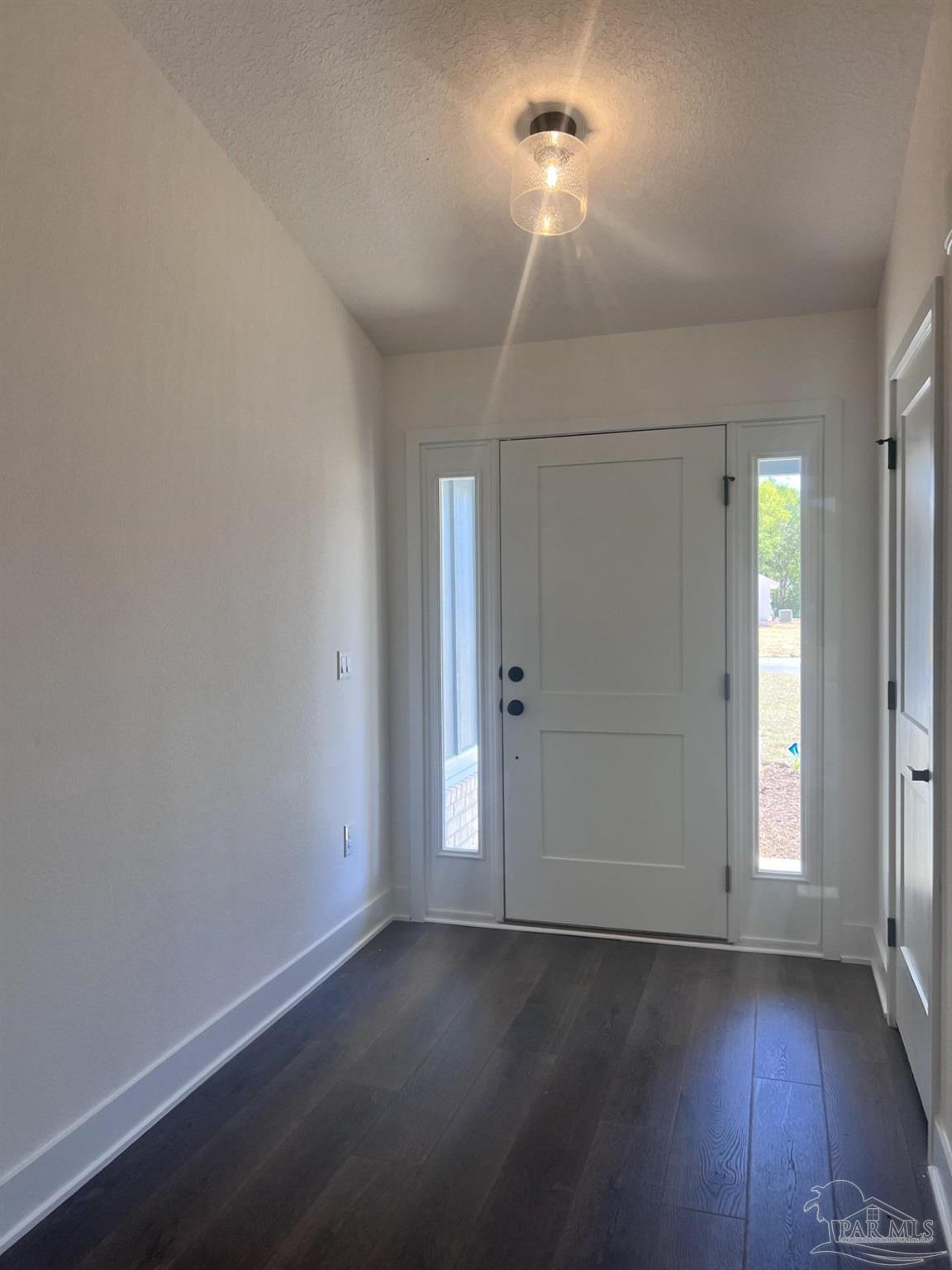 5232 Muscadine Way Milton, FL 32570 - Photo 4 of 23 an empty room with wooden floor and windows