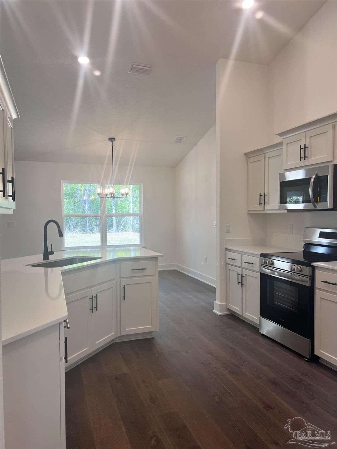 5232 Muscadine Way Milton, FL 32570 - Photo 5 of 23 a kitchen with granite countertop white cabinets and stainless steel appliances