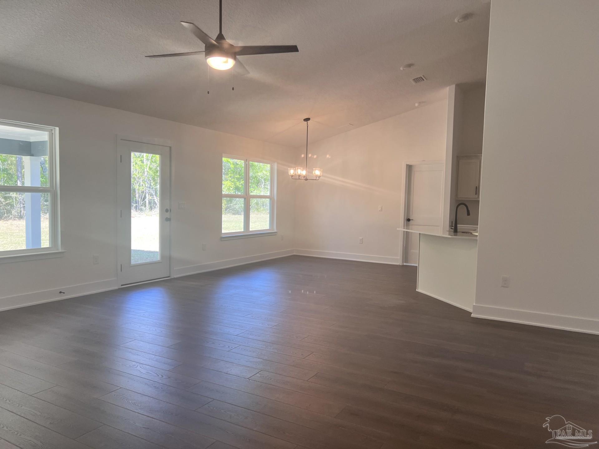 5232 Muscadine Way Milton, FL 32570 - Photo 9 of 23 an empty room with wooden floor and windows with curtains