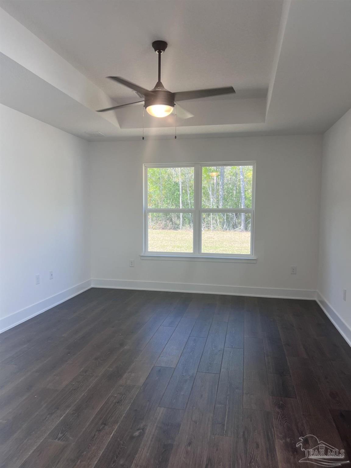 5232 Muscadine Way Milton, FL 32570 - Photo 10 of 23 an empty room with wooden floor chandelier fan and windows