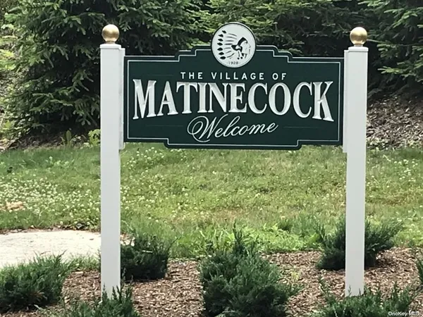 a view of a sign board with yard and mountain view