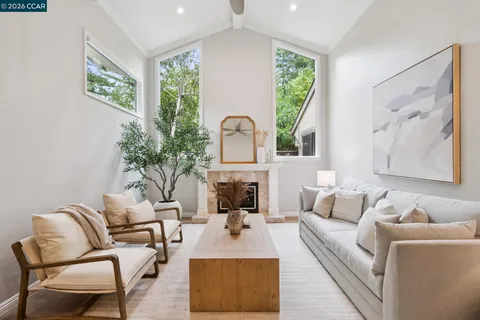 a living room with furniture fireplace and a large window