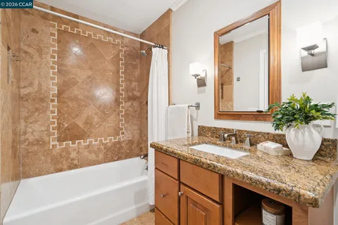 a bathroom with a granite countertop sink and a mirror