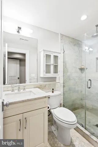 a bathroom with a sink toilet vanity and shower