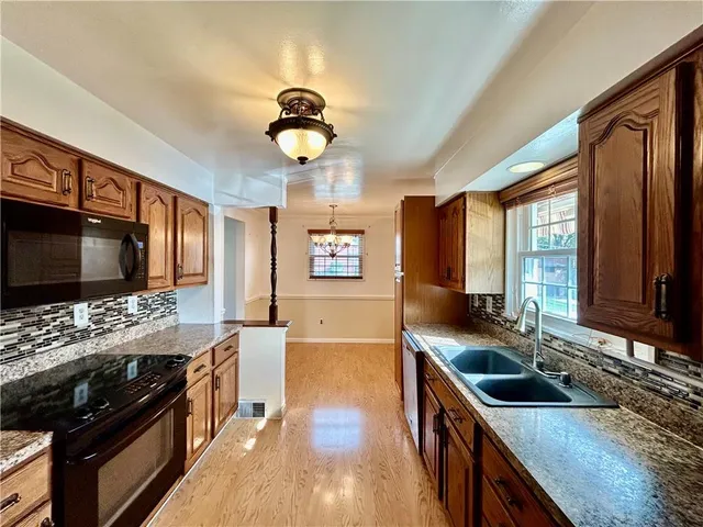 a kitchen with stainless steel appliances granite countertop a stove a sink and a microwave
