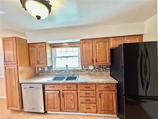 a kitchen with stainless steel appliances granite countertop a refrigerator and a sink