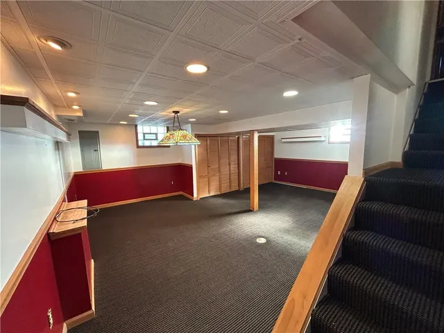 a view of an empty room with windows & cabinet