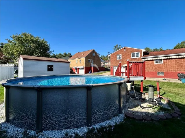 a view of a big house with a big yard and large trees
