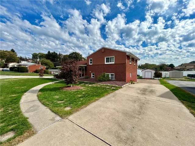 a front view of a house with a garden
