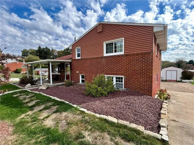 a view of a house with a big yard plants and large trees