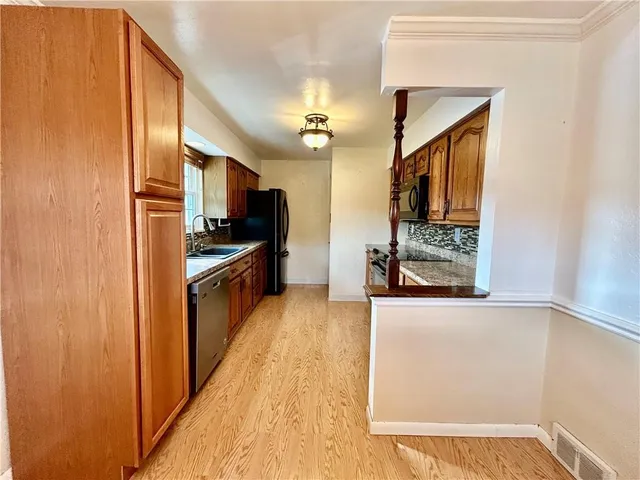 a kitchen with stainless steel appliances granite countertop a refrigerator and a sink