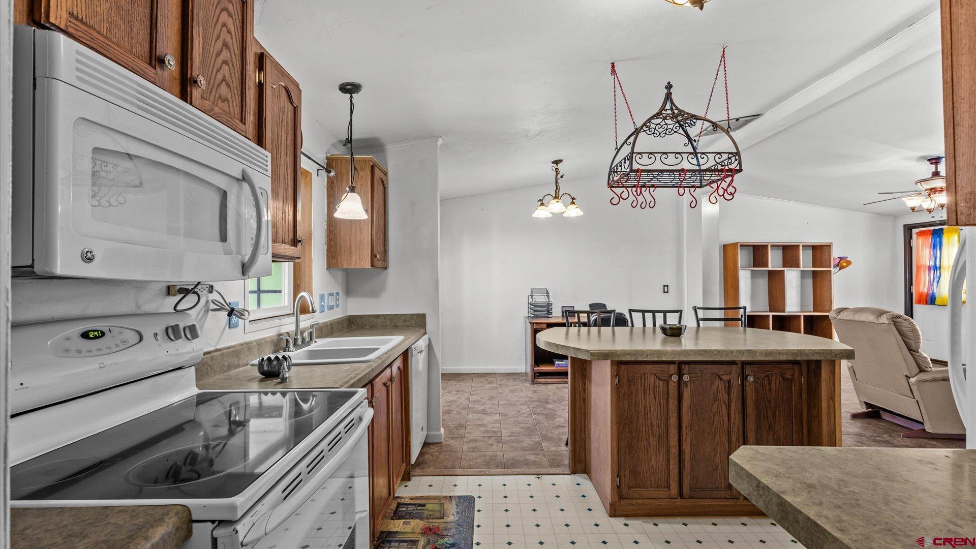777 1550th Road Delta, CO 81416 - Photo 13 of 32 a kitchen that has a sink a stove and a wooden table and chairs