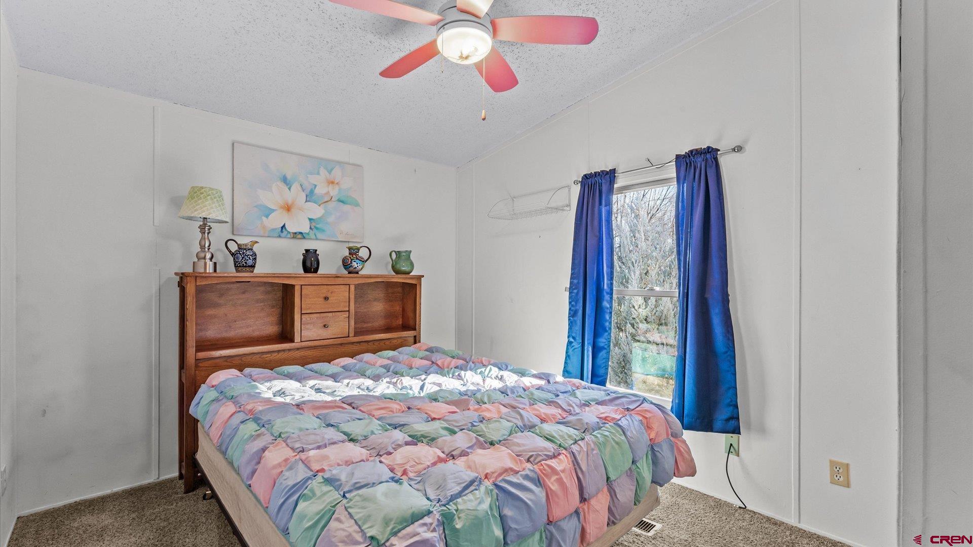 777 1550th Road Delta, CO 81416 - Photo 18 of 32 a bedroom with a bed and a chandelier