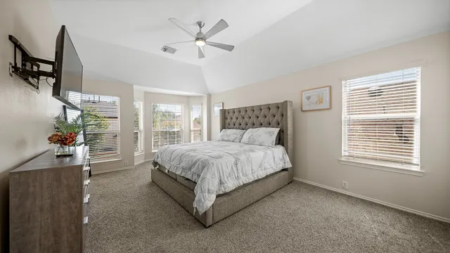 a spacious bedroom with a bed a couch and a window