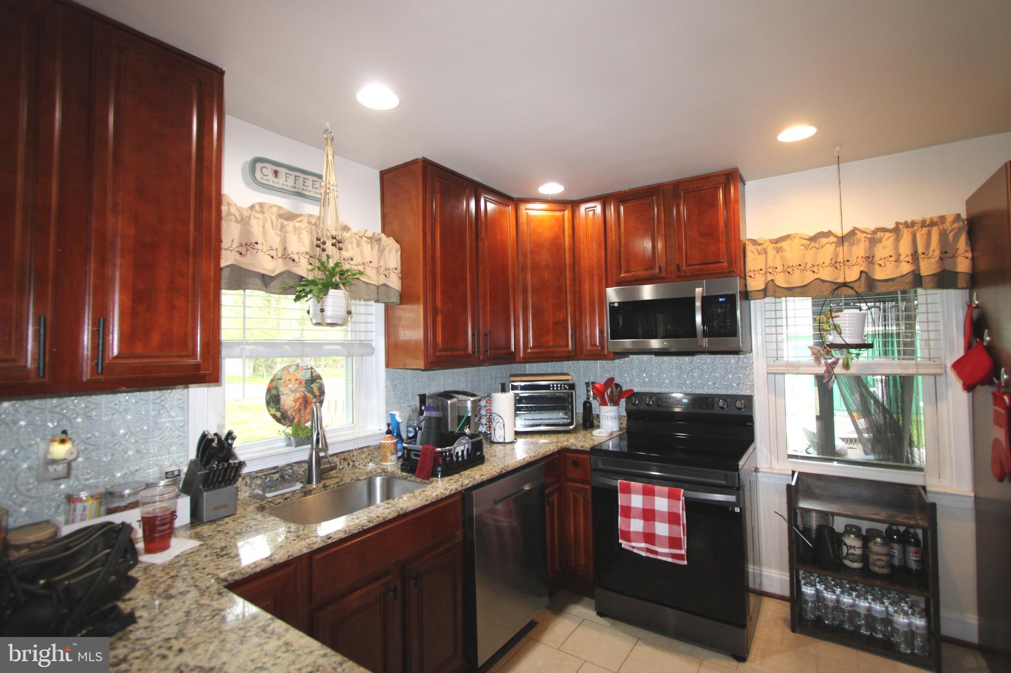 7802 Shelbourne Road Baltimore, MD 21226 - Photo 14 of 19 a kitchen with kitchen island granite countertop a stove sink and cabinets