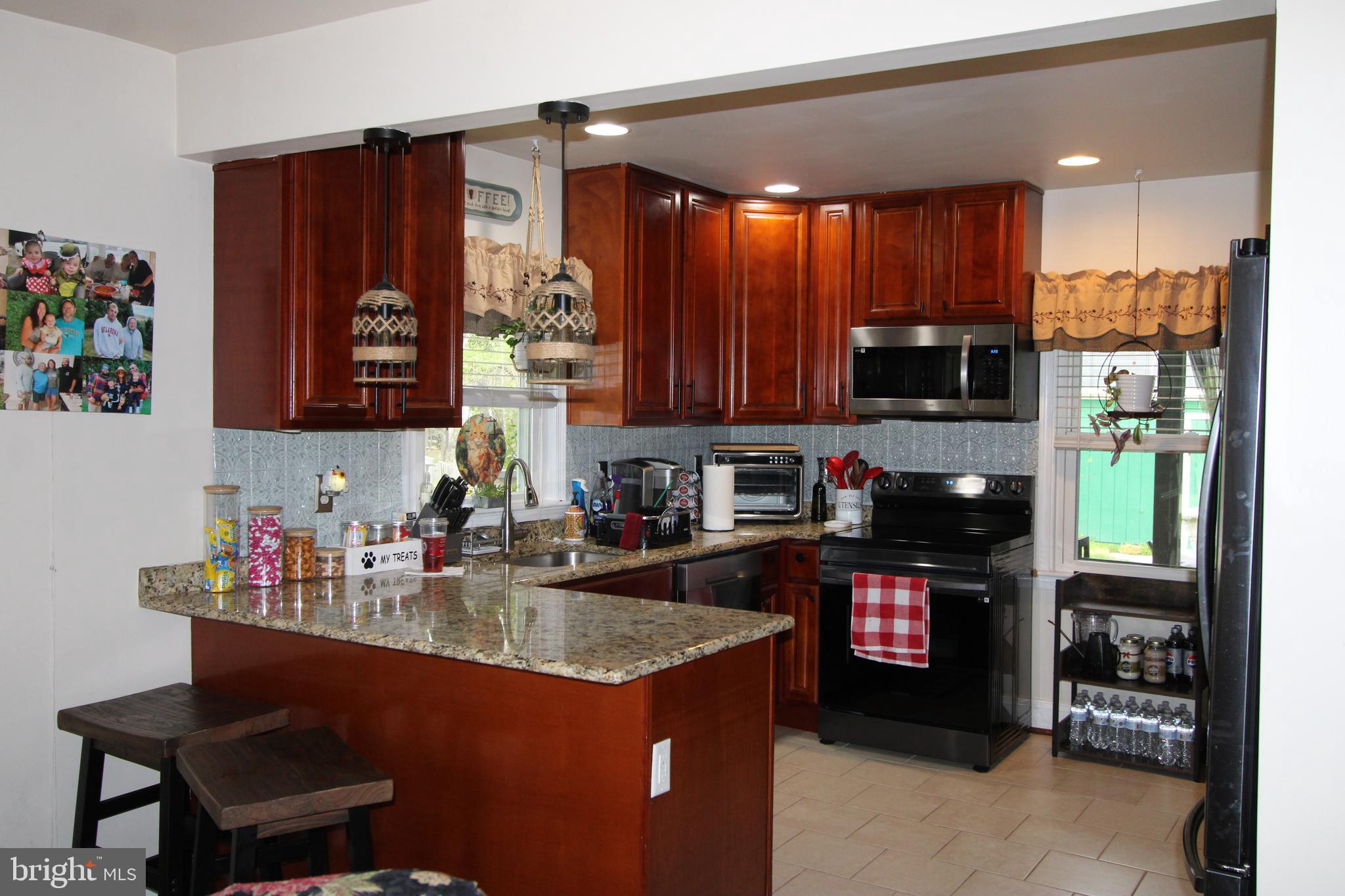 7802 Shelbourne Road Baltimore, MD 21226 - Photo 15 of 19 a kitchen with stainless steel appliances granite countertop a refrigerator and a stove top oven
