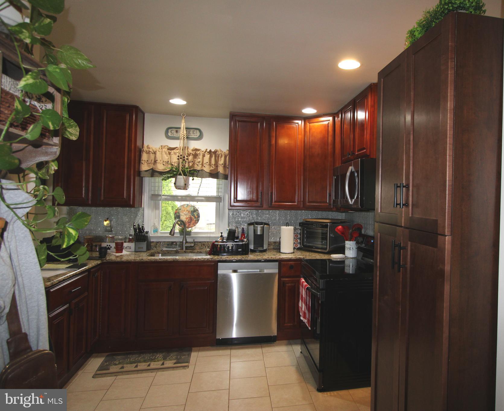 7802 Shelbourne Road Baltimore, MD 21226 - Photo 6 of 19 a kitchen with granite countertop stainless steel appliances a sink a counter top space cabinets and a window