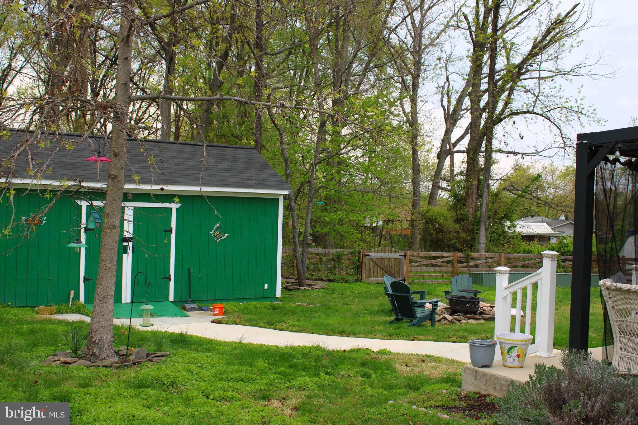 7802 Shelbourne Road Baltimore, MD 21226 - Photo 8 of 19 a view of a backyard with table and chairs and a large tree