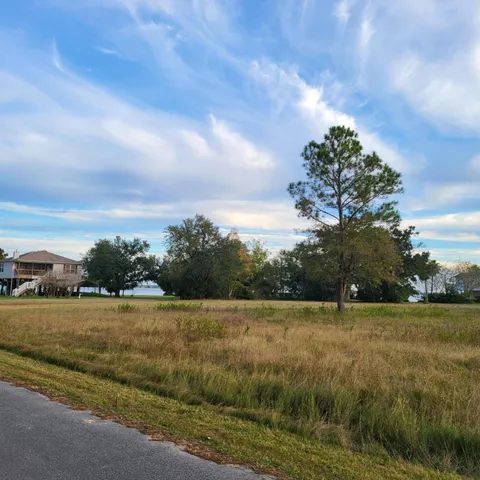a view of a green field with wooden fence