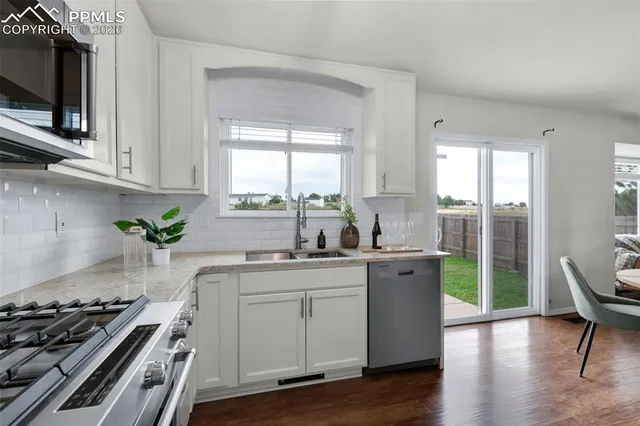 a kitchen with a stove a sink and a microwave