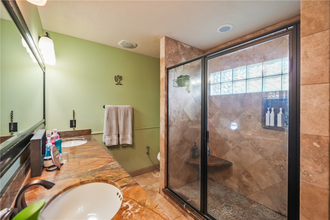 34366 Owens Road Hempstead, TX 77445 - Photo 23 of 31 a en suite bathroom with a granite countertop shower a sink and a mirror