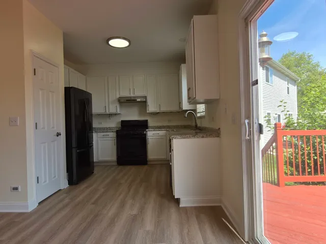 a kitchen with a refrigerator and a stove top oven