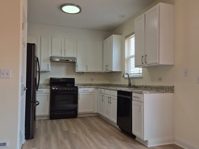 a kitchen with granite countertop a sink stainless steel appliances and cabinets