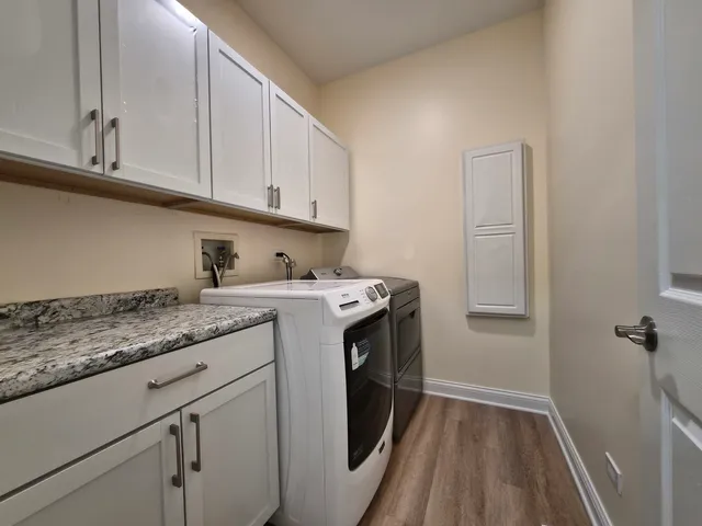 a utility room with cabinets washer and dryer