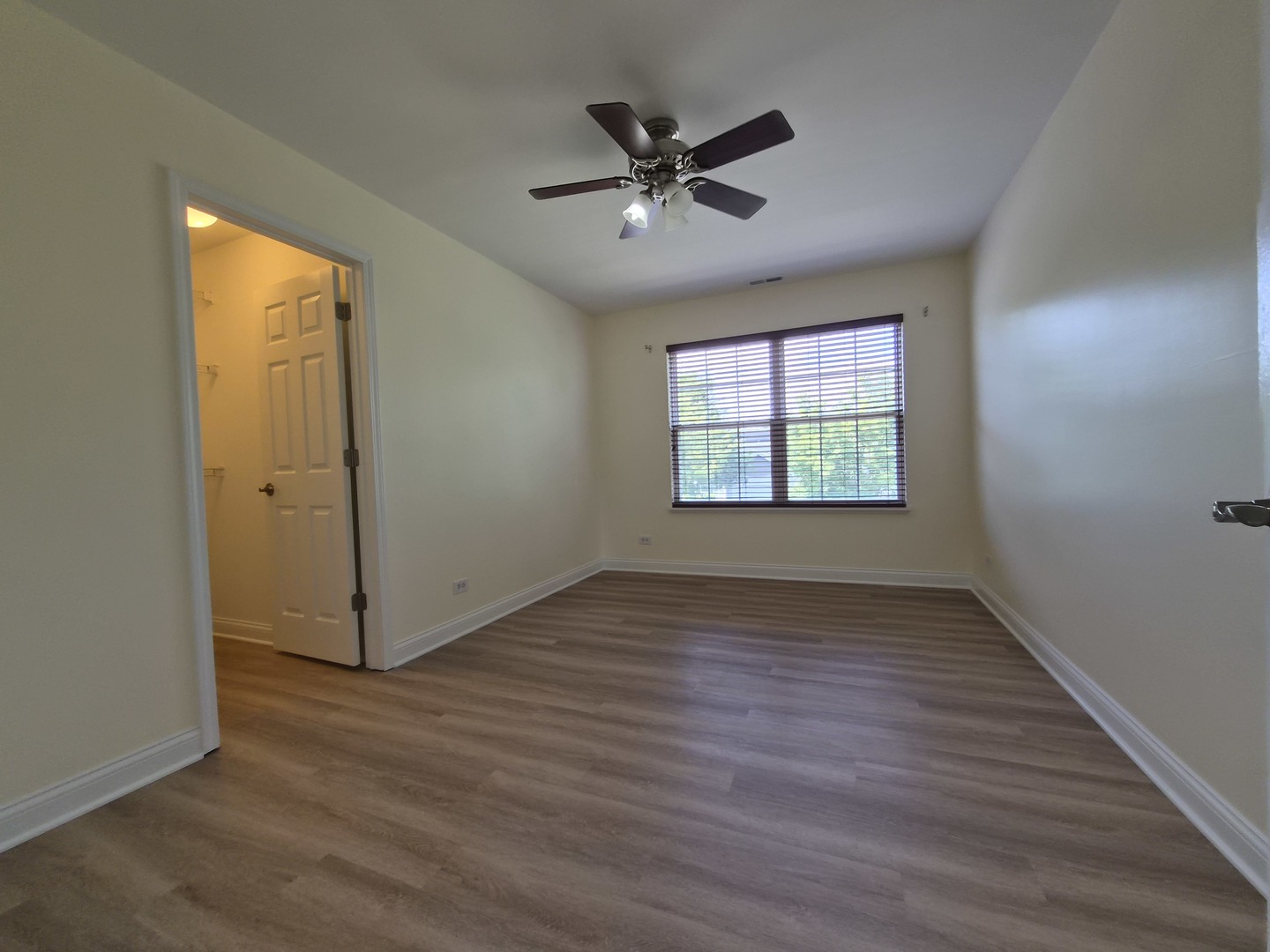 2355 Shiloh Drive Aurora, IL 60503 - Photo 19 of 40 an empty room with wooden floor fan and windows