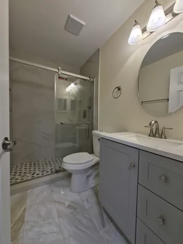 a bathroom with a sink a toilet and shower