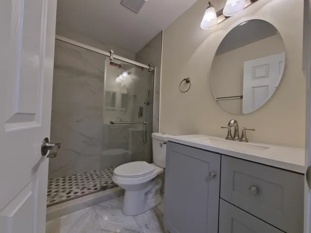 a bathroom with a sink a toilet and shower