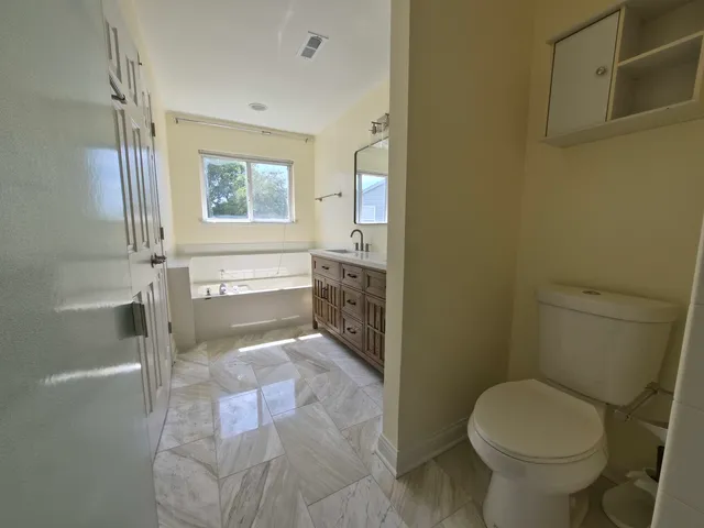 a bathroom with a granite countertop toilet a sink and bathtub