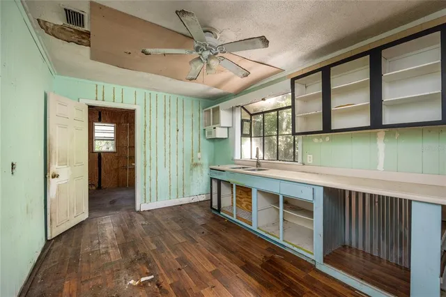 a view of a kitchen with a sink and dishwasher with wooden floor