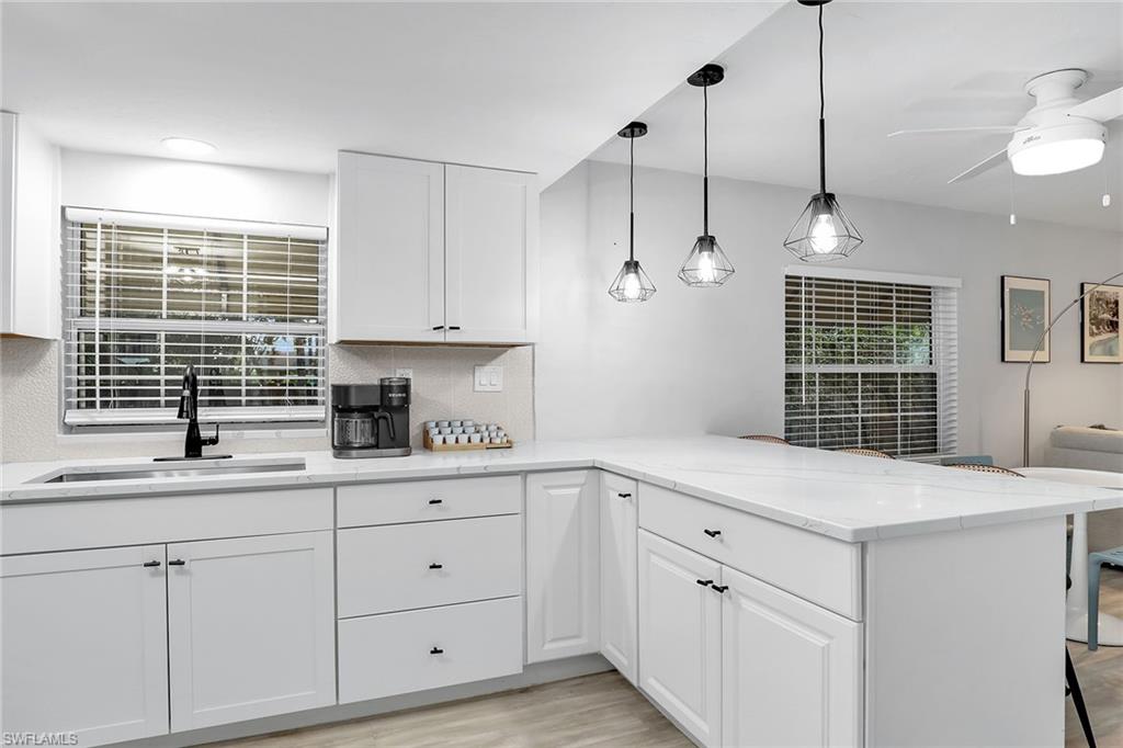 2780 Weeks Avenue Naples, FL 34112 - Photo 5 of 34 a kitchen with white cabinets and window