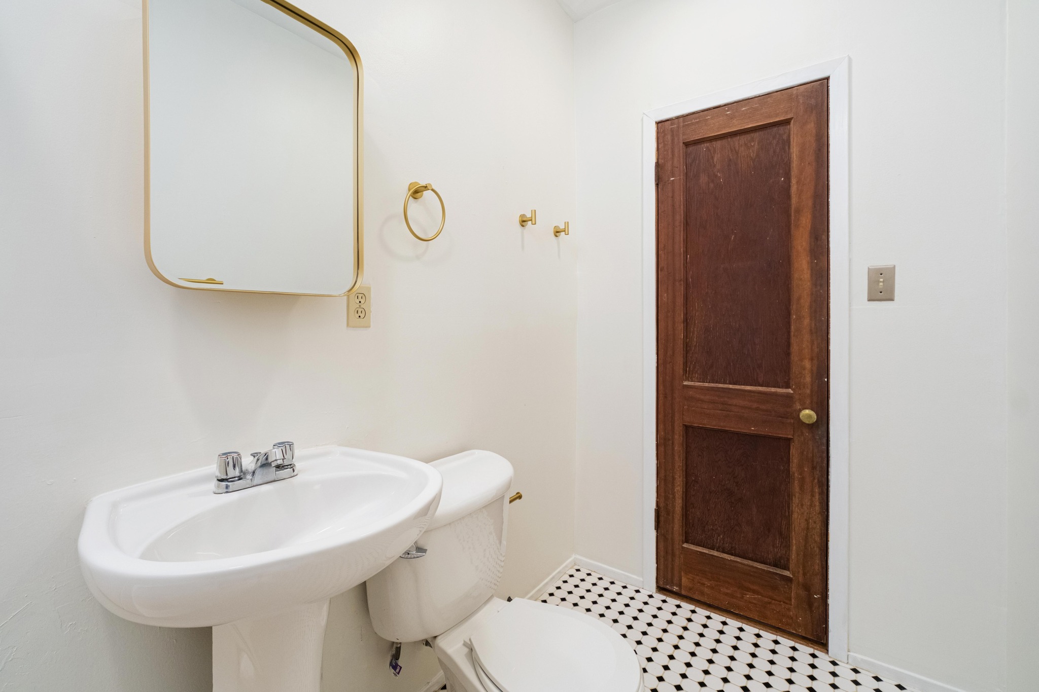 2012 Enfield Road, Unit B Austin, TX 78703 - Photo 17 of 20 Full bath features a pedestal sink and charming black and white tiled flooring.