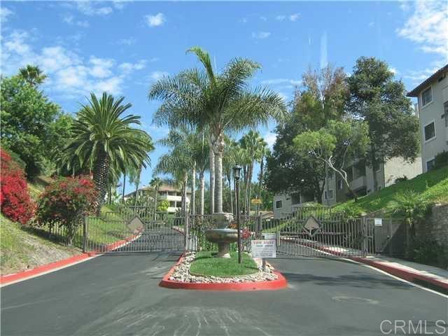 3545 Paseo De Francisco, Unit 225 Oceanside, CA 92056 - Photo 1 of 34 a backyard of a house with table and chairs plants and palm trees