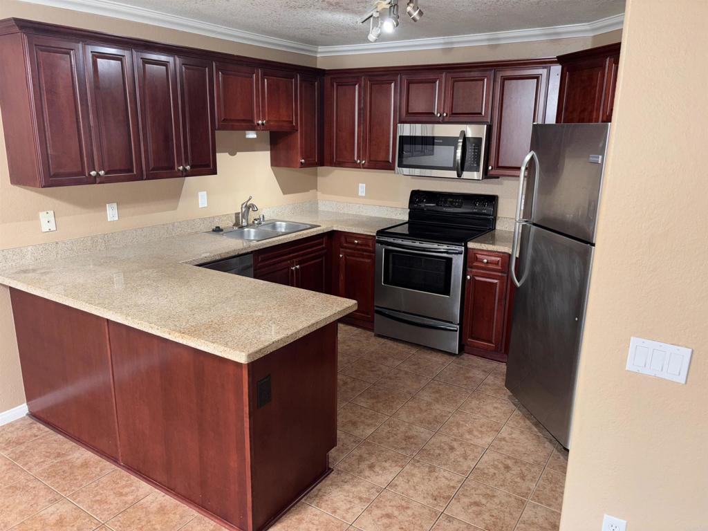 3545 Paseo De Francisco, Unit 225 Oceanside, CA 92056 - Photo 24 of 34 a kitchen with granite countertop a refrigerator stove and microwave