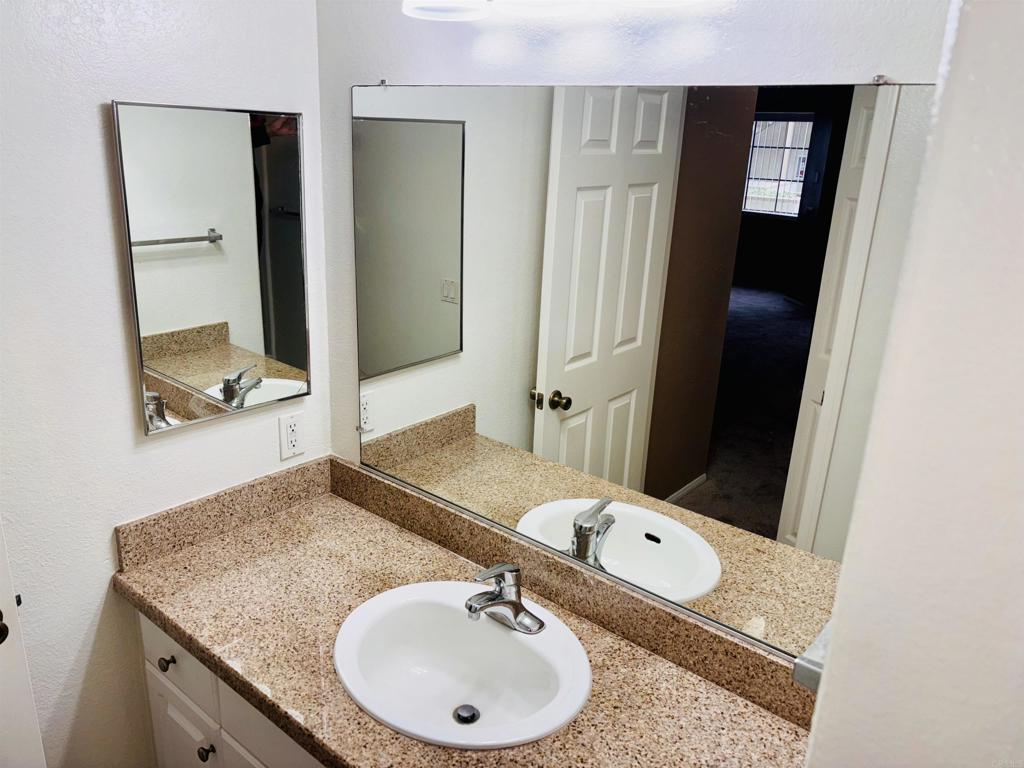 3545 Paseo De Francisco, Unit 225 Oceanside, CA 92056 - Photo 32 of 34 a bathroom with a granite countertop sink and a mirror