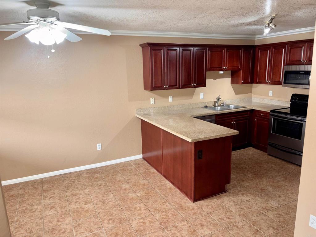 3545 Paseo De Francisco, Unit 225 Oceanside, CA 92056 - Photo 9 of 34 a kitchen with stainless steel appliances granite countertop a stove a sink dishwasher and a refrigerator with wooden cabinets
